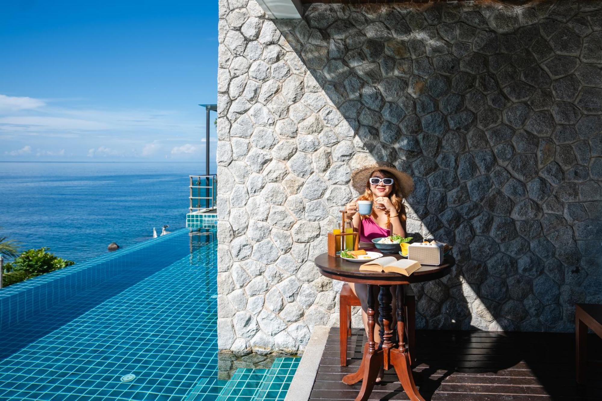 Zenmaya Oceanfront Phuket, Trademark Collection By Wyndham Patong Exterior photo A woman enjoying a morning coffee at the poolside of the resort